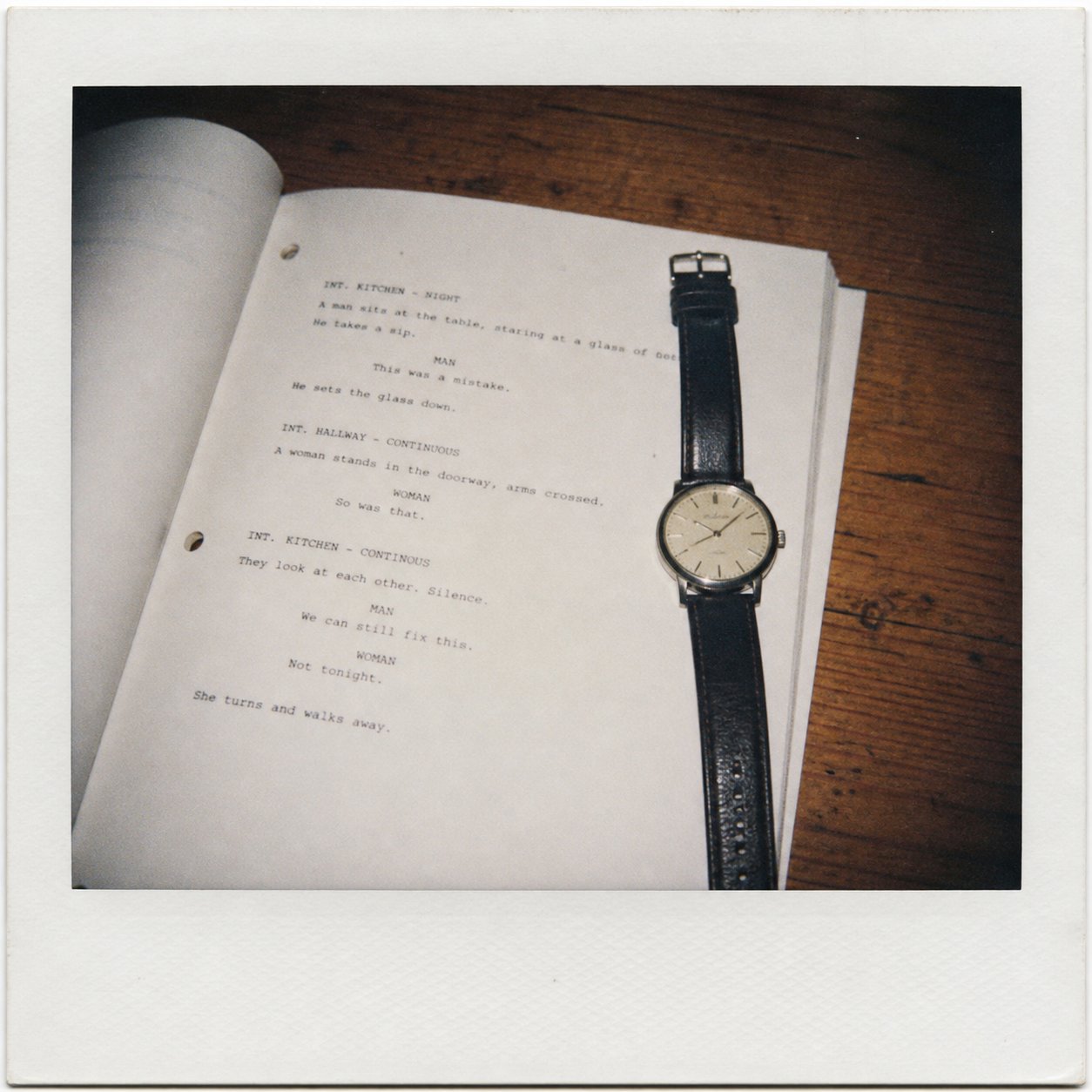 A screenplay page with a wristwatch resting on it.
