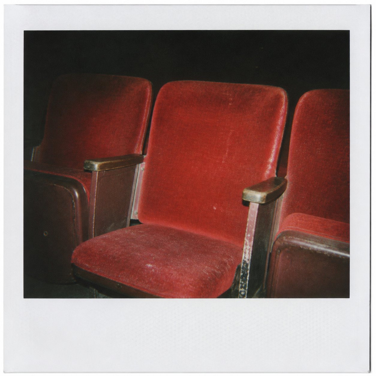 Red velvet seats in an empty old screening room.
